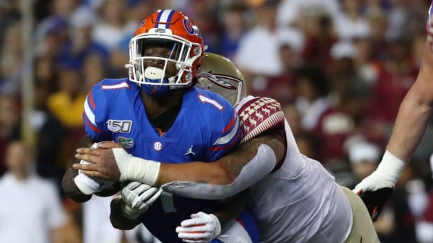Nov 30, 2019; Gainesville, FL, USA; Florida State Seminoles defensive tackle Cory Durden (16) tackles Florida Gators wide receiver Kadarius Toney (1) during the first quarter at Ben Hill Griffin Stadium.