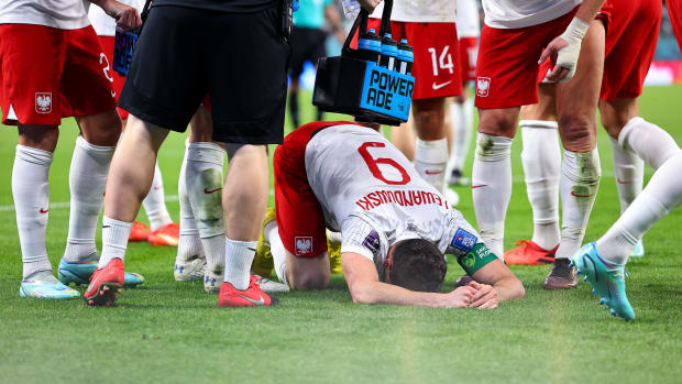 An emotional Robert Lewandowski pictured with his head on the ground after scoring the first goal of his World Cup career