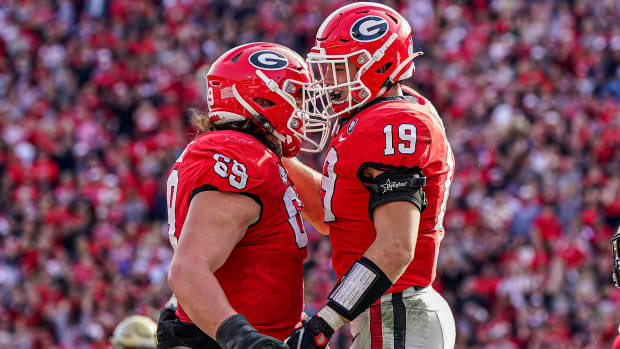 Georgia Bulldogs tight end Brock Bowers (19) reacts with offensive lineman Tate Ratledge (69) after catching a touchdown pass