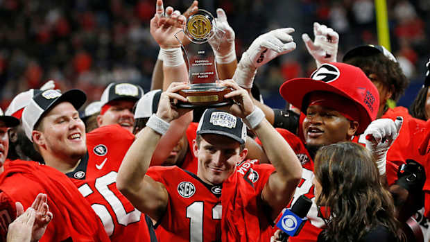 Georgia quarterback Stetson Bennett raises the SEC Championship MVP trophy after a victory against LSU.