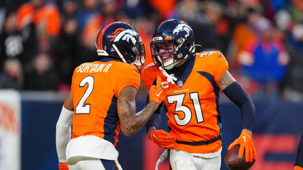 Denver Broncos safety Justin Simmons (31) celebrates his second interception with Denver Broncos cornerback Pat Surtain II (2) against the Arizona Cardinals at Empower Field at Mile High.
