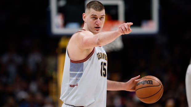 Nikola Jokic points to a player before making a pass.