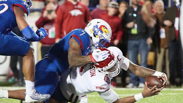 Dec 28, 2022; Memphis, TN, USA; Arkansas Razorbacks quarterback KJ Jefferson (1) rushes for a touchdown in the first quarter as Kansas Jayhawks linebacker Lorenzo McCaskill (7) defends in the 2022 Liberty Bowl at Liberty Bowl Memorial Stadium. Mandatory Credit: Nelson Chenault-USA TODAY Sports