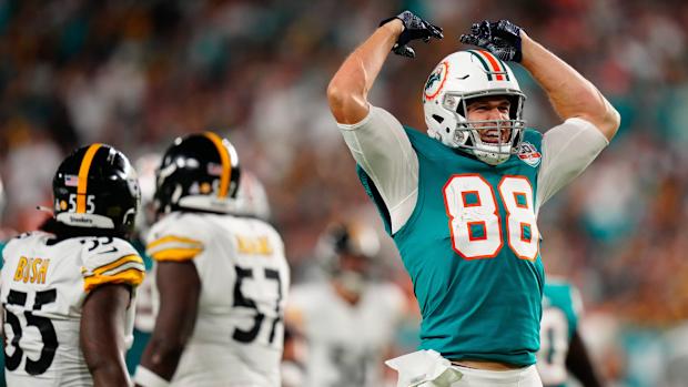 Miami Dolphins tight end Mike Gesicki throws his hands up in celebration