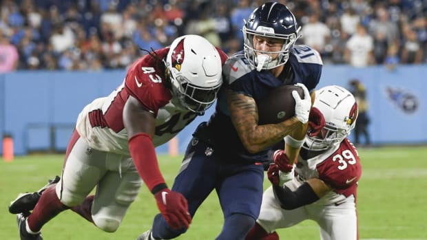 Tennessee Titans wide receiver Mason Kinsey (12) runs the ball against Arizona Cardinals linebacker Jesse Luketa (43) and cornerback Jace Whittaker (39) after a catch during the fourth quarter of a preseason game at Nissan Stadium.