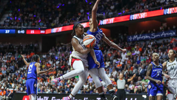 Las Vegas Aces guard Chelsea Gray drives past Connecticut Sun forward Alyssa Thomas to go for a layup