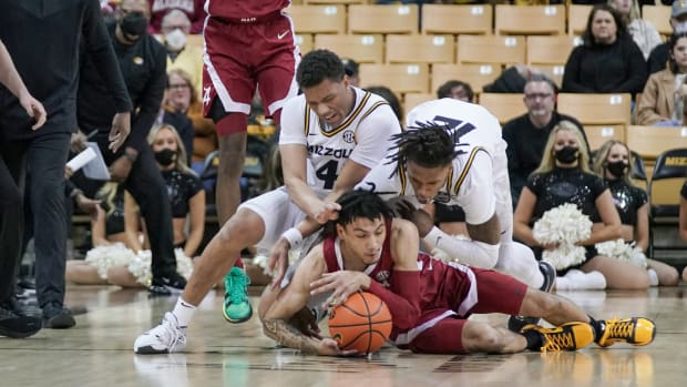 Missouri Tigers guard Javon Pickett (4) and guard DaJuan Gordon (12) and Alabama Crimson Tide guard Jahvon Quinerly (13) fight for a loose ball during the first half at Mizzou Arena.