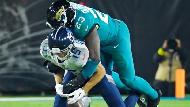 Jacksonville Jaguars linebacker Foyesade Oluokun (23) breaks up a pass play to Tennessee Titans wide receiver Nick Westbrook-Ikhine (15) during third quarter action. The Jacksonville Jaguars hosted the Tennessee Titans to decide the AFC South championship at TIAA Bank Field in Jacksonville, FL, Saturday, January 7, 2023. The Jaguars went into the half trailing 7 to 13 but came back to win with a final score of 20 to 16.