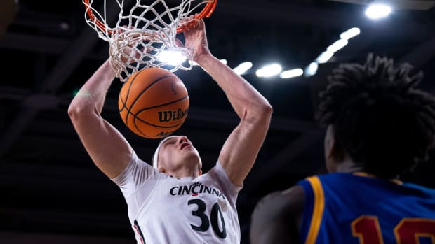 Cincinnati Bearcats forward Viktor Lakhin (30) dunks as Tulsa Golden Hurricane forward Tim Dalger (10) looks on in the first half of the NCAA men s basketball game at Fifth Third Arena in Cincinnati. Ncaa Basketball Tulsa Golden Hurricane At Cincinnati Bearcats