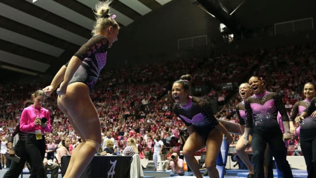 Alabama gymnast Mati Waligora celebrates with teammates after her 9.8 performance on the balance beam at Coleman Coliseum.