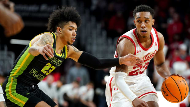 Cincinnati Bearcats guard Mika Adams-Woods (23) drives as South Florida Bulls guard Caleb Murphy (23) defends in the second half of a men's NCAA basketball game, Saturday, Feb. 26, 2022, at Fifth Third Arena in Cincinnati. The South Florida Bulls won, 54-52. South Florida Bulls At Cincinnati Bearcats Basketball 072