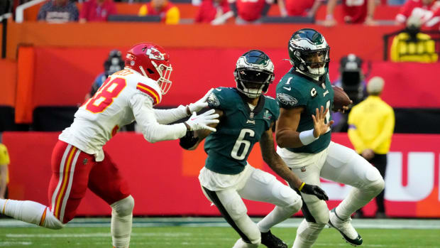 Feb 12, 2023; Glendale, AZ, USA; Philadelphia Eagles quarterback Jalen Hurts (1) scrambles with the ball as wide receiver DeVonta Smith (6) blocks Kansas City Chiefs cornerback L'Jarius Sneed (38) during the first quarter in Super Bowl LVII at State Farm Stadium.
