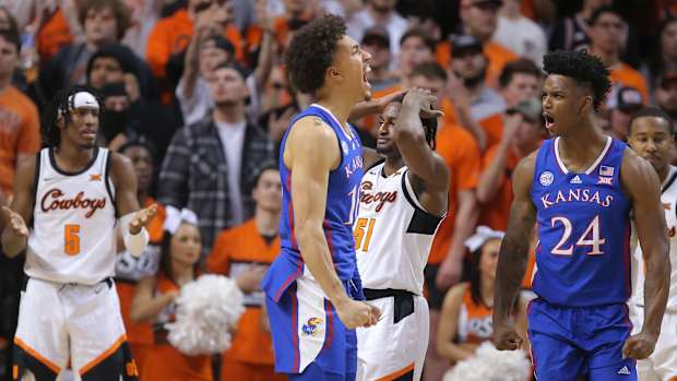 Kansas Jayhawks forward Jalen Wilson (10) and forward K.J. Adams Jr. (24) celebrate beside Oklahoma State Cowboys guards Caleb Asberry (5) and John-Michael Wright (51) during a men's college basketball game between the Oklahoma State University Cowboys and the Kansas Jayhawks at Gallagher-Iba Arena in Stillwater, Okla., Wednesday, Feb. 15, 2023.