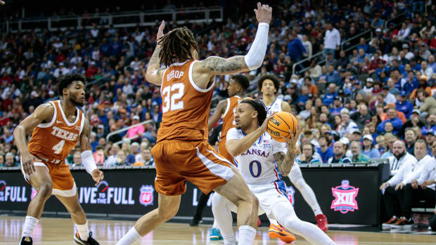 Mar 11, 2023; Kansas City, MO, USA; Kansas Jayhawks guard Bobby Pettiford Jr. (0) looks for an opening around Texas Longhorns forward Christian Bishop (32) during the first half at T-Mobile Center.