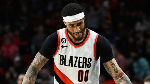 Former Trailblazers Gary Payton II high-fives fans in the crowd during a game.