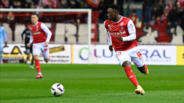 Reims forward Folarin Balogun drives up the field.