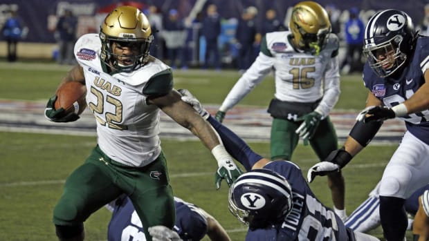 Dec 18, 2021; Shreveport, LA, USA; UAB Blazers running back DeWayne McBride (22) breaks a tackle against the BYU Cougars linebacker Max Tooley (31) during the fourth quarter during the 2021 Independence Bowl at Independence Stadium.