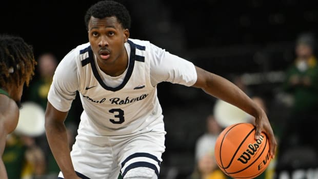 Oral Roberts point guard dribbles a basketball during a game.