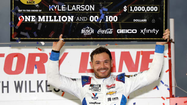 Kyle Larson celebrates with the $1 million dollar check in victory lane Sunday night after winning the NASCAR Cup Series All-Star Race at North Wilkesboro Speedway. (Photo by Chris Graythen/Getty Images)