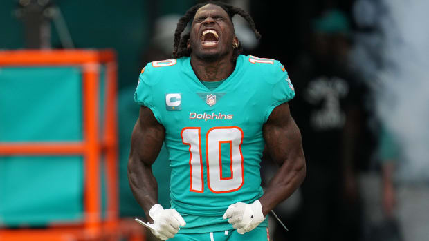 Tyreek Hill yells as he points his head up to the air and flexes his arms in front of him