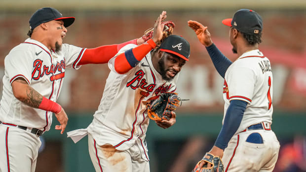 Jun 7, 2023; Cumberland, Georgia, USA; Atlanta Braves shortstop Orlando Arcia (11) centerfielder Michael Harris II (23) and second baseman Ozzie Albies (1) react after the Braves defeated the New York Mets at Truist Park. Mandatory Credit: Dale Zanine-USA TODAY Sports