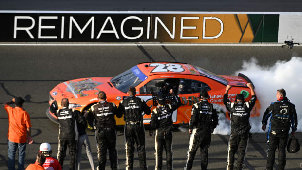 Aric Almirola, driver of the #28 Michael Roberts Construction Ford, celebrates with a burnout as crew cheers after winning the NASCAR Xfinity Series DoorDash 250 at Sonoma Raceway on June 10, 2023 in Sonoma, California. (Photo by Logan Riely/Getty Images)