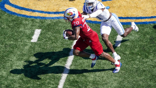 Sep 24, 2022; Lawrence, Kansas, USA; Kansas Jayhawks running back Daniel Hishaw Jr. (20) runs the ball as Duke Blue Devils defensive back Darius Joiner (1) attempts the tackle during the second half of the game at David Booth Kansas Memorial Stadium.