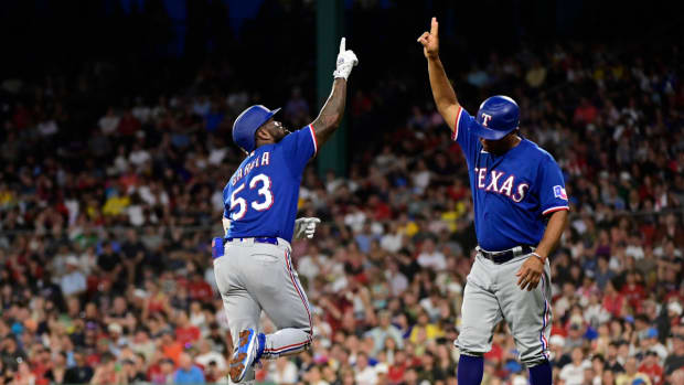 Texas Rangers right fielder Adolis Garcia, left, celebrates his two-run home run against the Boston Red Sox during the sixth inning at Fenway Park with third-base coach Tony Beasley.