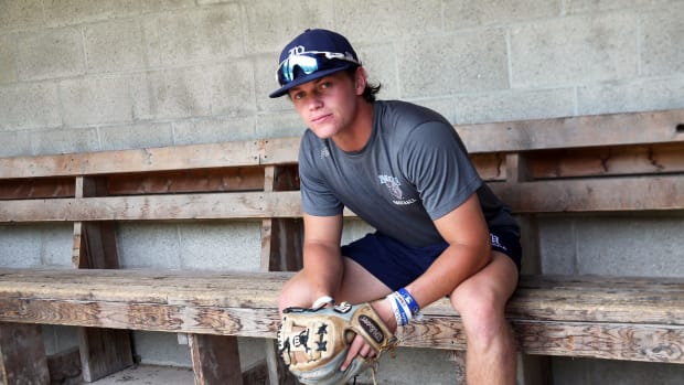 SF Giants fifth-round pick Quinn McDaniel sits on wooden seats in a dugout. (2023)