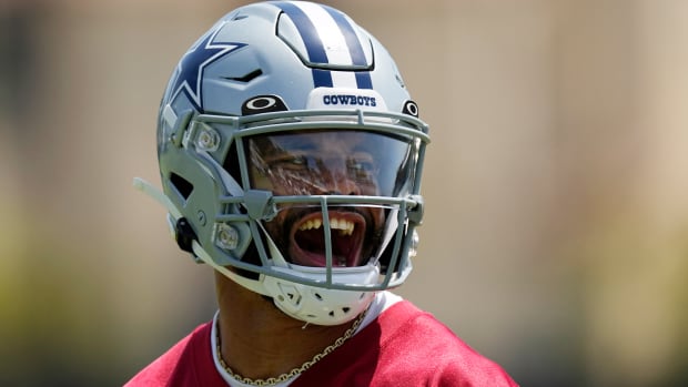 Cowboys quarterback Dak Prescott reacts as he successfully completes a pass during a drill.