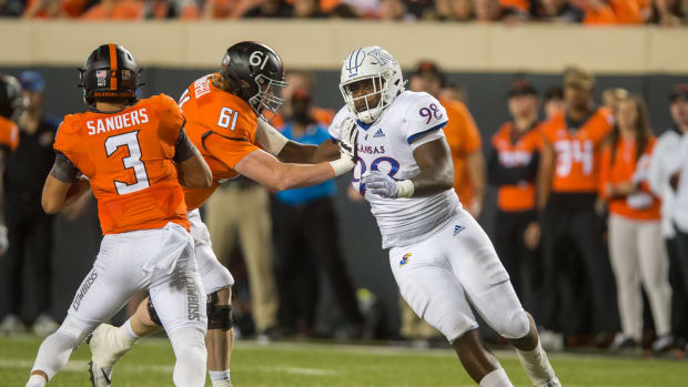 Oct 30, 2021; Stillwater, Oklahoma, USA; Kansas Jayhawks defensive lineman Caleb Sampson (98) gets around Oklahoma State Cowboys offensive lineman Jake Springfield (61) as he rushes quarterback Spencer Sanders (3) during the second quarter at Boone Pickens Stadium. Oklahoma State won 55-3. Mandatory Credit: Brett Rojo-USA TODAY Sports