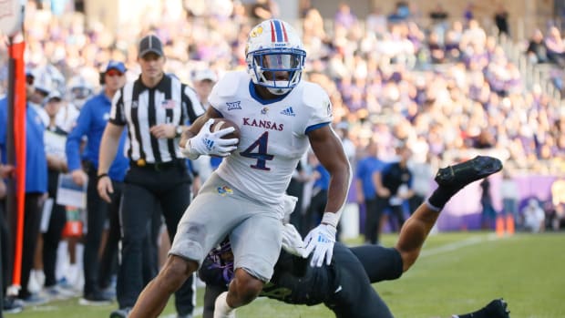 Nov 20, 2021; Fort Worth, Texas, USA; Kansas Jayhawks running back Devin Neal (4) turns the corner on TCU Horned Frogs linebacker Jamoi Hodge (6) during the first half at Amon G. Carter Stadium. Mandatory Credit: Raymond Carlin III-USA TODAY Sports