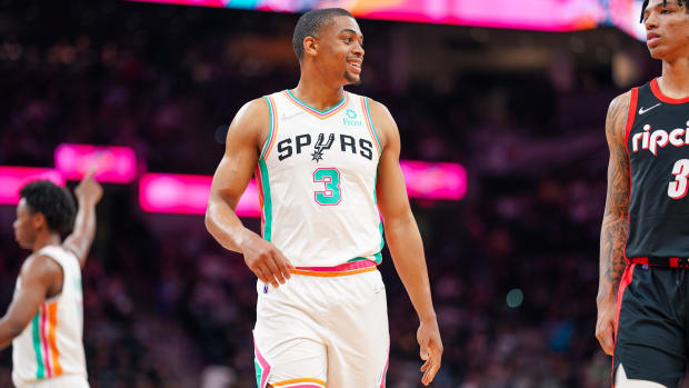 Spurs forward Keldon Johnson (3) smiles as he looks on in the second half of a game against the Trail Blazers.