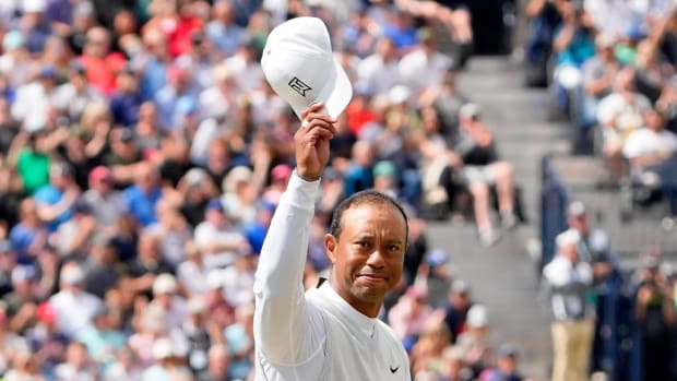 Tiger Woods tips his hat to the crowd after teeing off on the 18th hole during the second round of the 150th Open Championship golf tournament at St. Andrews Old Course.