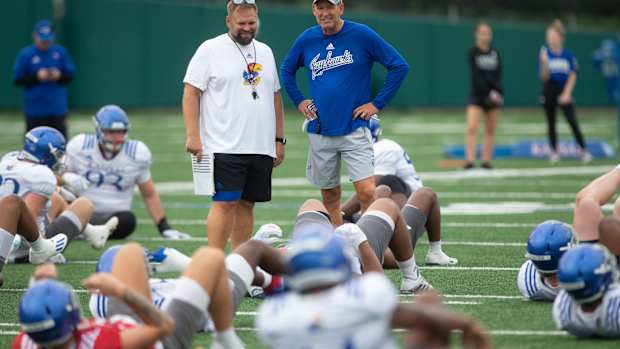 Kansas head coach Lance Leipold, right, talks with offensive coordinator Andy Kotelnicki, left, as players begin practice Thursday morning.