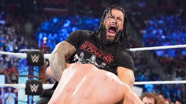 Roman Reigns puts Drew McIntyre in a headlock