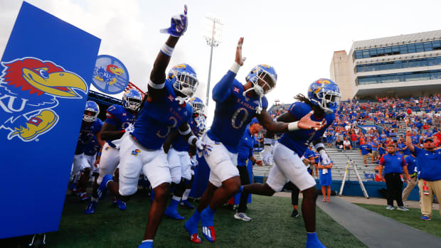 Kansas football players run out of the tunnel on to David Booth Kansas Memorial Stadium during their opening game against South Dakota on Sept. 3, 2021.