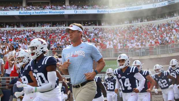 Lane Kiffin running out with Ole Miss Football.
