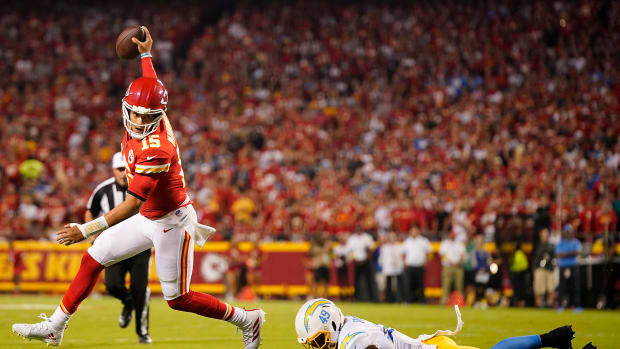 Sep 15, 2022; Kansas City, Missouri, USA; Kansas City Chiefs quarterback Patrick Mahomes (15) runs the ball ahead of Los Angeles Chargers linebacker Drue Tranquill (49) during the first half at GEHA Field at Arrowhead Stadium. Mandatory Credit: Jay Biggerstaff-USA TODAY Sports