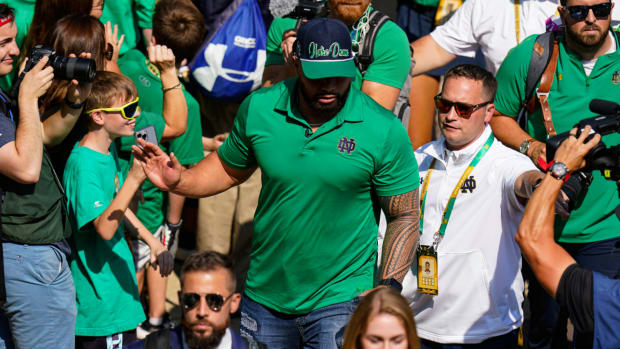 Former Notre Dame player Manti Te’o follows members of the Notre Dame football team walk through the crowd to the stadium before an NCAA college football game against California in South Bend, Ind., Saturday, Sept. 17, 2022. (AP Photo/Michael Conroy)