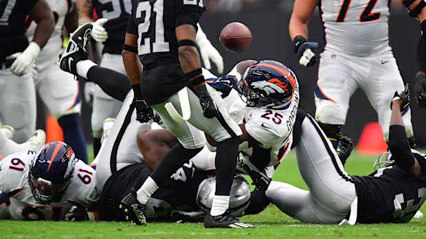 Denver Broncos running back Melvin Gordon III (25) loses the ball against the Las Vegas Raiders during the first half at Allegiant Stadium.