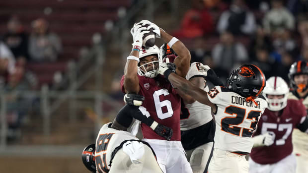 Stanford Cardinal wide receiver Elijah Higgins (6) holds onto a pass against Oregon State Beavers defensive backs Kitan Oladapo (28) and Ryan Cooper Jr. (23) during the second quarter at Stanford Stadium.