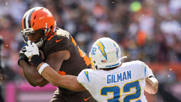 Oct 9, 2022; Cleveland, Ohio, USA; Cleveland Browns running back Nick Chubb (24) breaks a tackle of Los Angeles Chargers safety Alohi Gilman (32) during the third quarter at FirstEnergy Stadium. Mandatory Credit: Scott Galvin-USA TODAY Sports