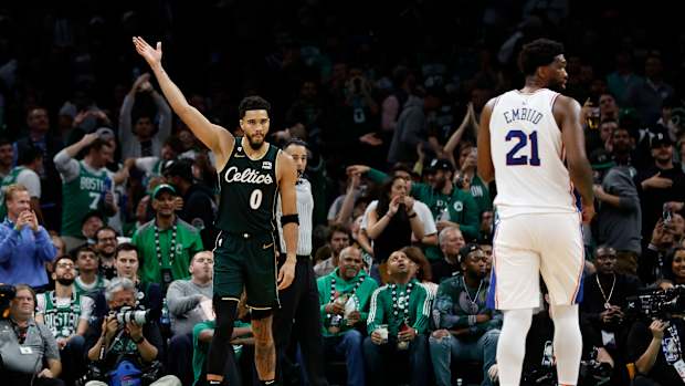 Boston Celtics forward Jayson Tatum (0) acknowledges the crowd as Philadelphia 76ers center Joel Embiid (21) looks away during the fourth quarter at TD Garden.