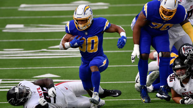 Dec 13, 2020; Inglewood, California, USA; Los Angeles Chargers running back Austin Ekeler (30) breaks free from Atlanta Falcons defensive end Allen Bailey (93) during a first quarter running play at SoFi Stadium. Mandatory Credit: Robert Hanashiro-USA TODAY Sports