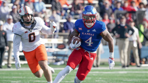 Nov 5, 2022; Lawrence, Kansas, USA; Kansas Jayhawks running back Devin Neal (4) runs the ball as Oklahoma State Cowboys linebacker Mason Cobb (0) defends during the first half of the game at David Booth Kansas Memorial Stadium.