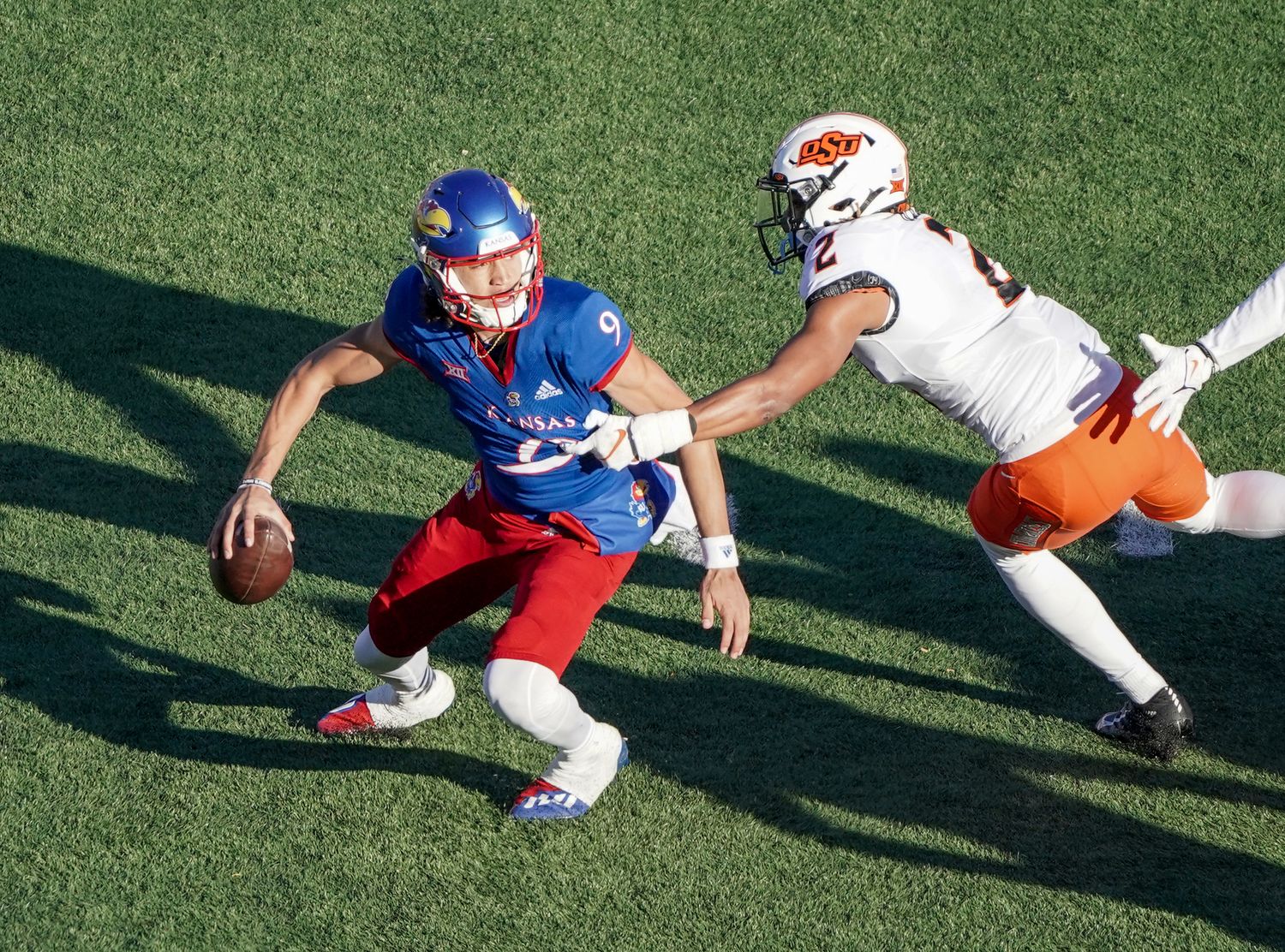 Nov 5, 2022; Lawrence, Kansas, USA; Kansas Jayhawks quarterback Jason Bean (9) scrambles to avoid Oklahoma State Cowboys cornerback Korie Black (2) during the second half of the game at David Booth Kansas Memorial Stadium. Mandatory Credit: Denny Medley-USA TODAY Sports