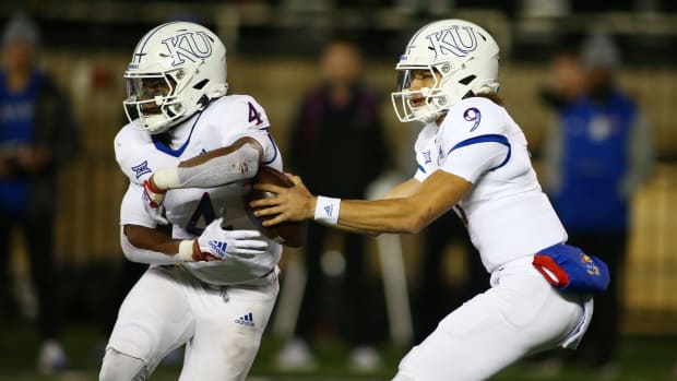 Nov 12, 2022; Lubbock, Texas, USA; Kansas Jayhawks quarterback Jason Bean (9) fakes a handoff to running back Devin Neal (4) in the second half against the Texas Tech Red Raiders at Jones AT&T Stadium and Cody Campbell Field. Mandatory Credit: Michael C. Johnson-USA TODAY Sports