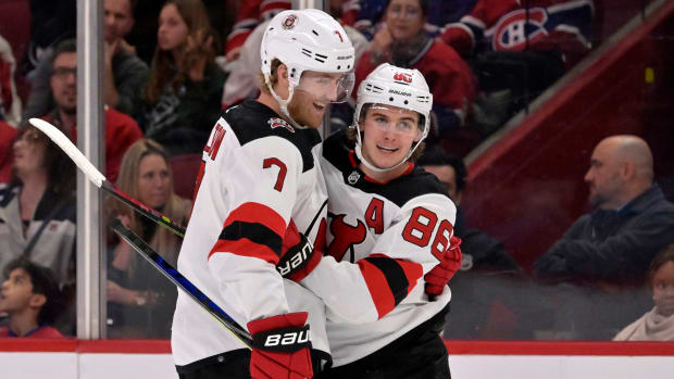 Dougie Hamilton and Jack Hughes celebrate after a Devils goal