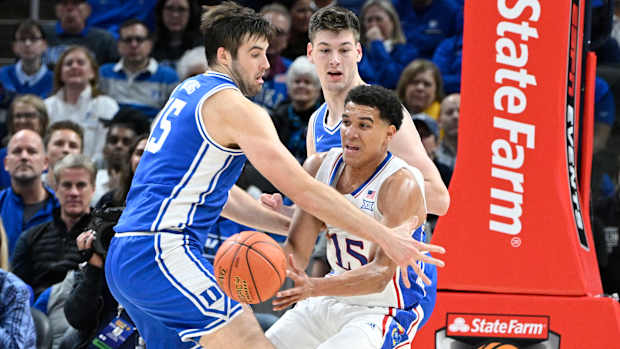 Nov 15, 2022; Indianapolis, Indiana, USA; Kansas Jayhawks guard Kevin McCullar Jr. (15) passes the ball away from Duke Blue Devils center Ryan Young (15) during the first half at Gainbridge Fieldhouse. Mandatory Credit: Marc Lebryk-USA TODAY Sports